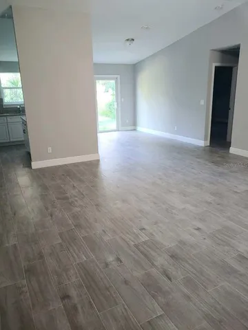 a view of an empty room with closet and window