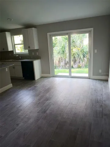 a view of a kitchen with wooden floor and a window