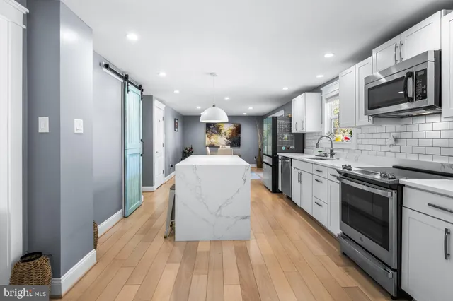 a kitchen with stainless steel appliances granite countertop a refrigerator stove microwave and sink