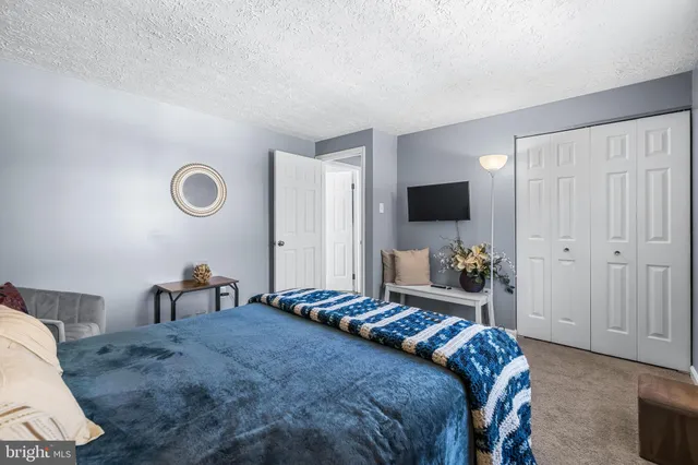a bedroom with a bed and a flat tv screen on dresser