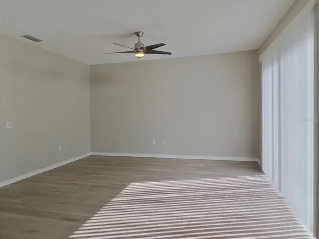 a view of an empty room with wooden floor