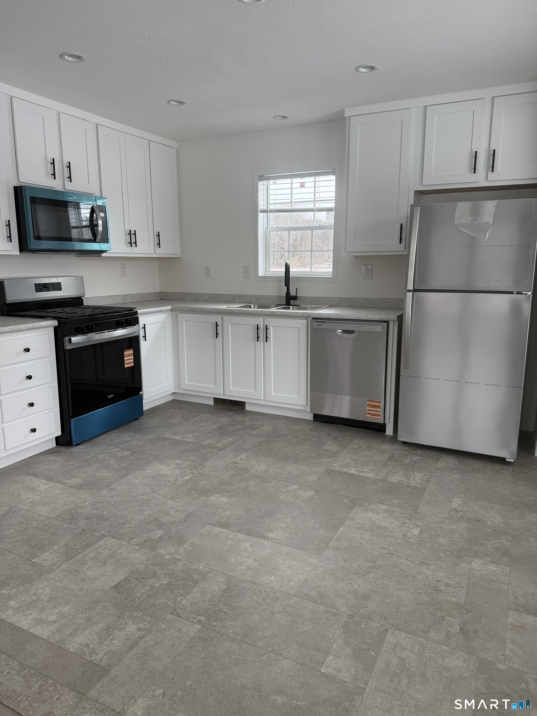 4-421 Norwich-Westerly Road North Stonington, CT 06359 - Photo 2 of 12 a kitchen with white cabinets and stainless steel appliances