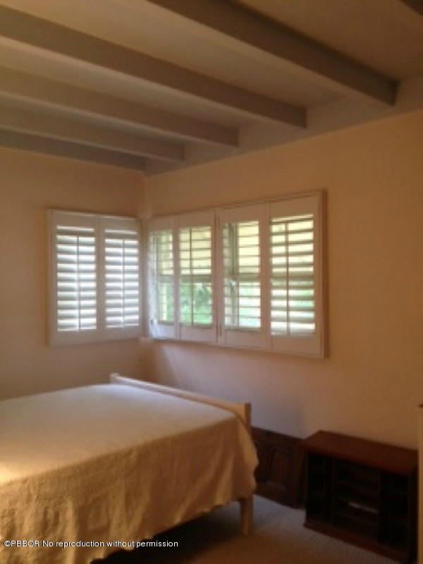 249 Alpine Road West Palm Beach, FL 33405 - Photo 12 of 16 a bed sitting in a bedroom next to a window