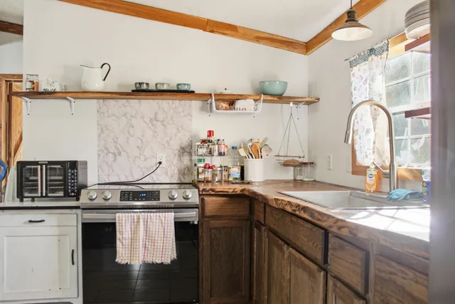 a kitchen with sink a stove and cabinets