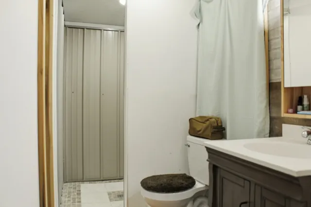 a bathroom with a granite countertop sink and a toilet