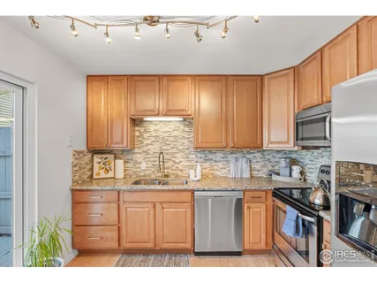 a kitchen with kitchen island granite countertop a sink cabinets and stainless steel appliances