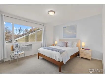 a bedroom with a bed and large windows