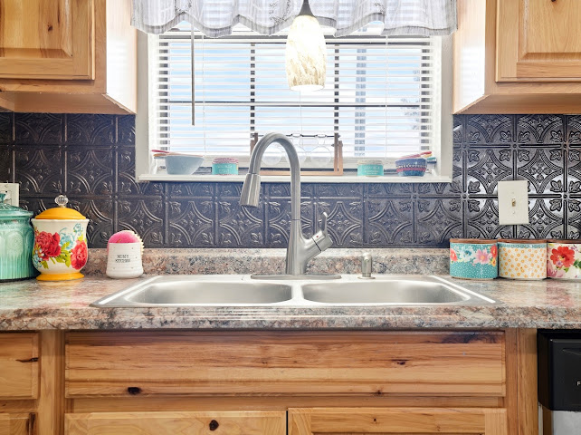 30063 South 4300th Road Stigler, OK 74462 - Photo 14 of 58 Stainless steel double basin sink, brushed nickel high-arc faucet, decorative backsplash, wood cabinetry, and laminate countertop