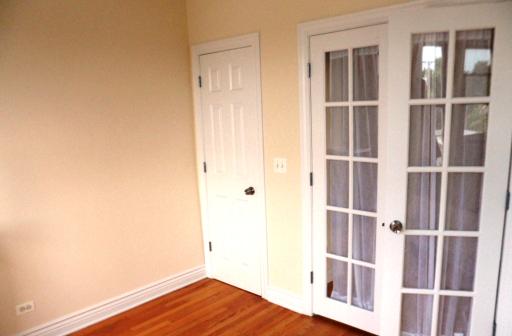 2450 West Addison Street, Unit 2B Chicago, IL 60618 - Photo 9 of 10 a view of a bedroom with wooden floor and fence