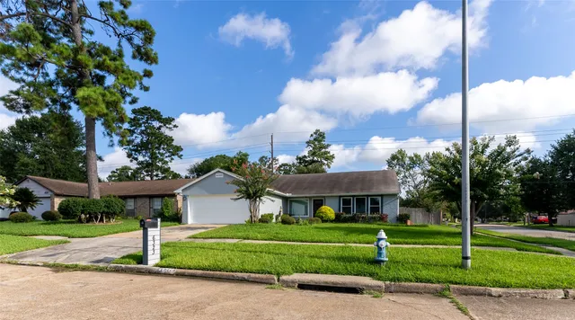 a view of a house with a yard and tree s