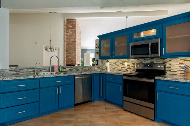a kitchen with stainless steel appliances granite countertop a stove sink and cabinets