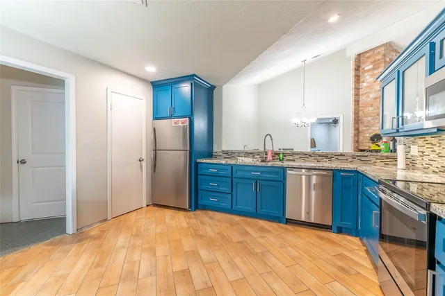 a kitchen with stainless steel appliances granite countertop a refrigerator sink and cabinets