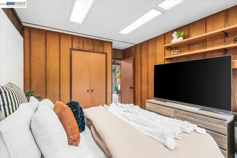 a bedroom with bed and a flat tv screen