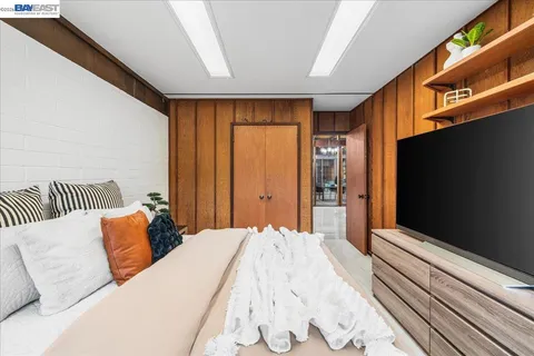 a bedroom with a bed and a flat tv screen