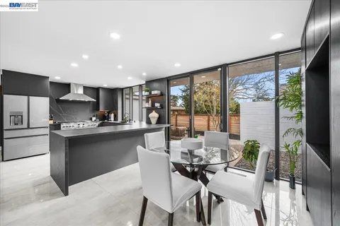 a kitchen with a table chairs refrigerator and microwave