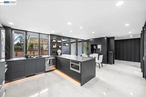 a kitchen with stainless steel appliances granite countertop a stove and a large window