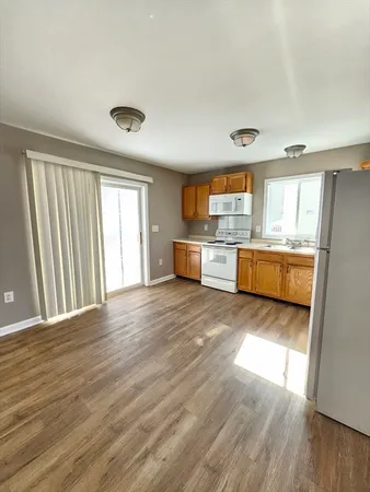 a large kitchen with kitchen island wooden floors and stainless steel appliances
