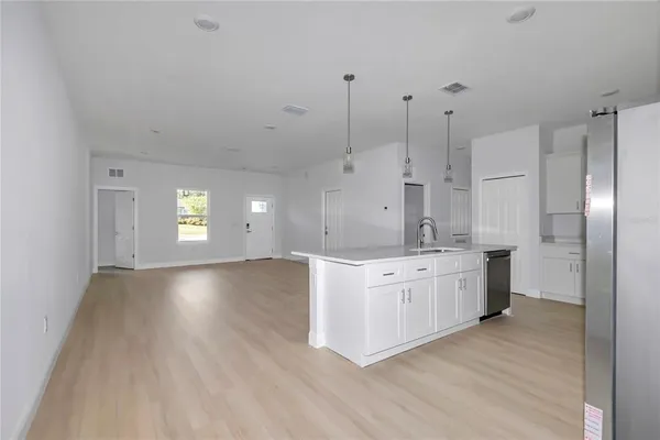 a large kitchen with kitchen island a sink stainless steel appliances and cabinets