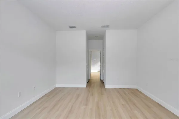 a view of an empty room with wooden floor