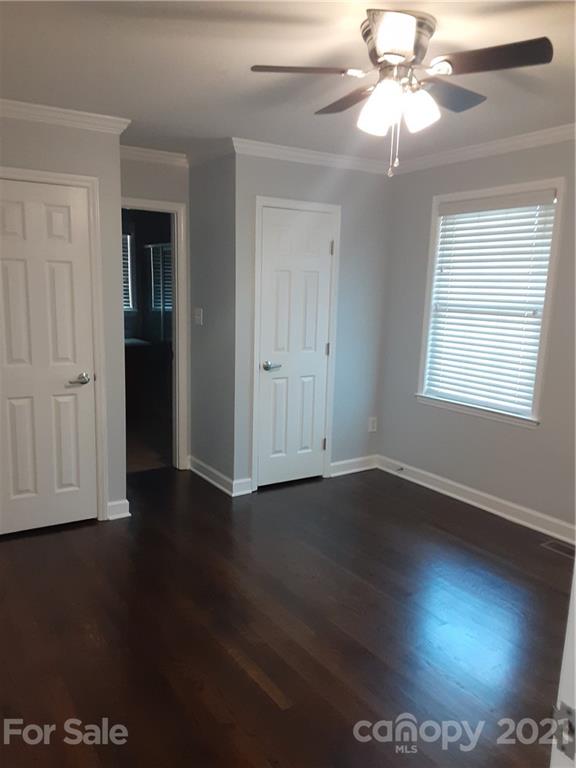 1501 Tyvola Road Charlotte, NC 28210 - Photo 13 of 20 an empty room with wooden floor chandelier fan and windows