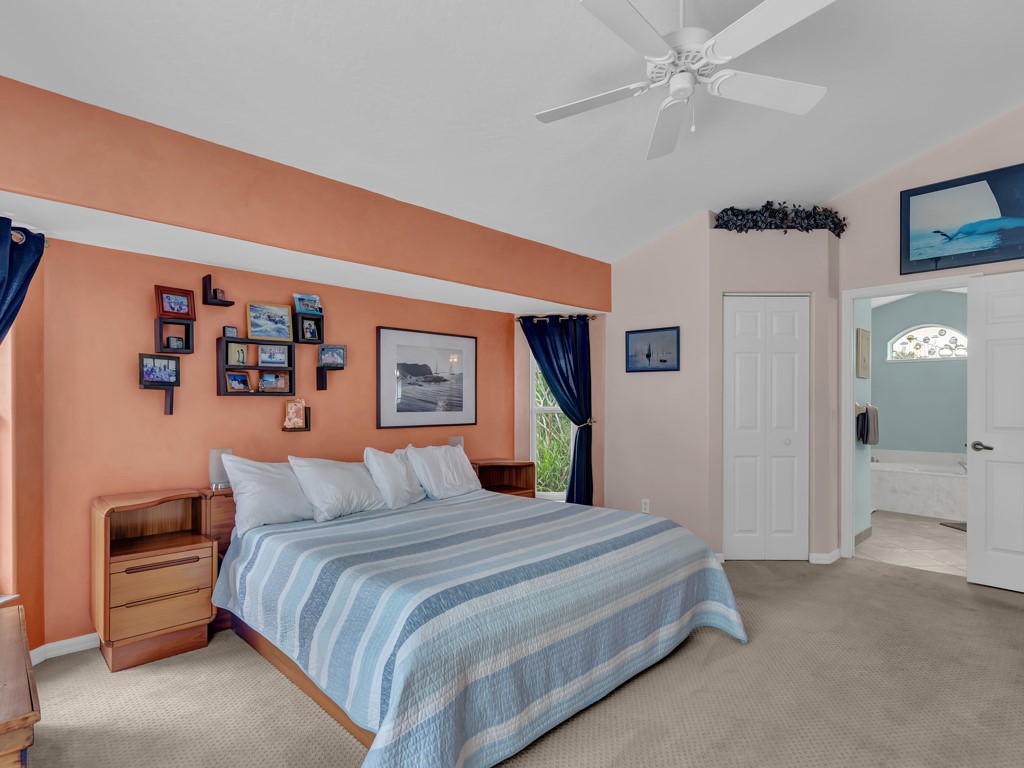 109 Thunderbird Drive Sebastian, FL 32958 - Photo 20 of 27 a bedroom with a large bed and a chandelier
