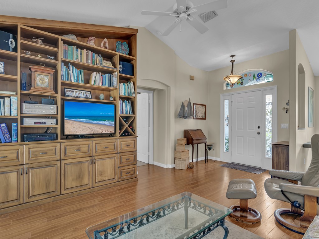 109 Thunderbird Drive Sebastian, FL 32958 - Photo 6 of 27 a living room with furniture a bookshelf and wooden floor