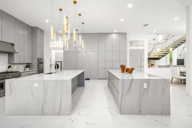 a kitchen with stainless steel appliances a table and chairs in it