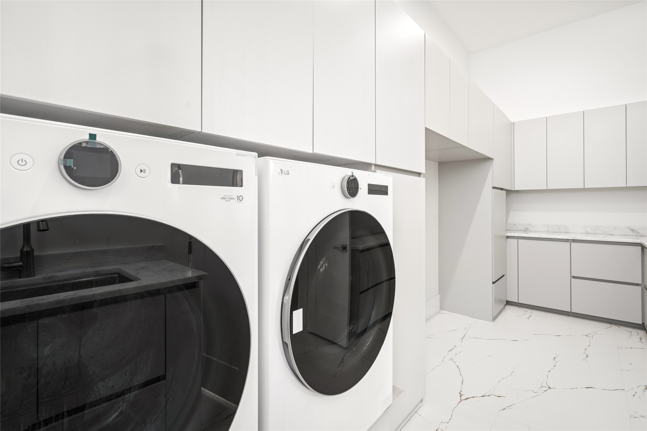 625 Piney Point Road Houston, TX 77024 - Photo 21 of 47 The spacious utility room is both stylish and highly functional, featuring an abundance of built-in cabinets and drawers, ample counter space for folding, and an LG washer and dryer. Thoughtfully designed, it also offers room for two additional refrigerators or freezers—ideal for flexible storage needs.