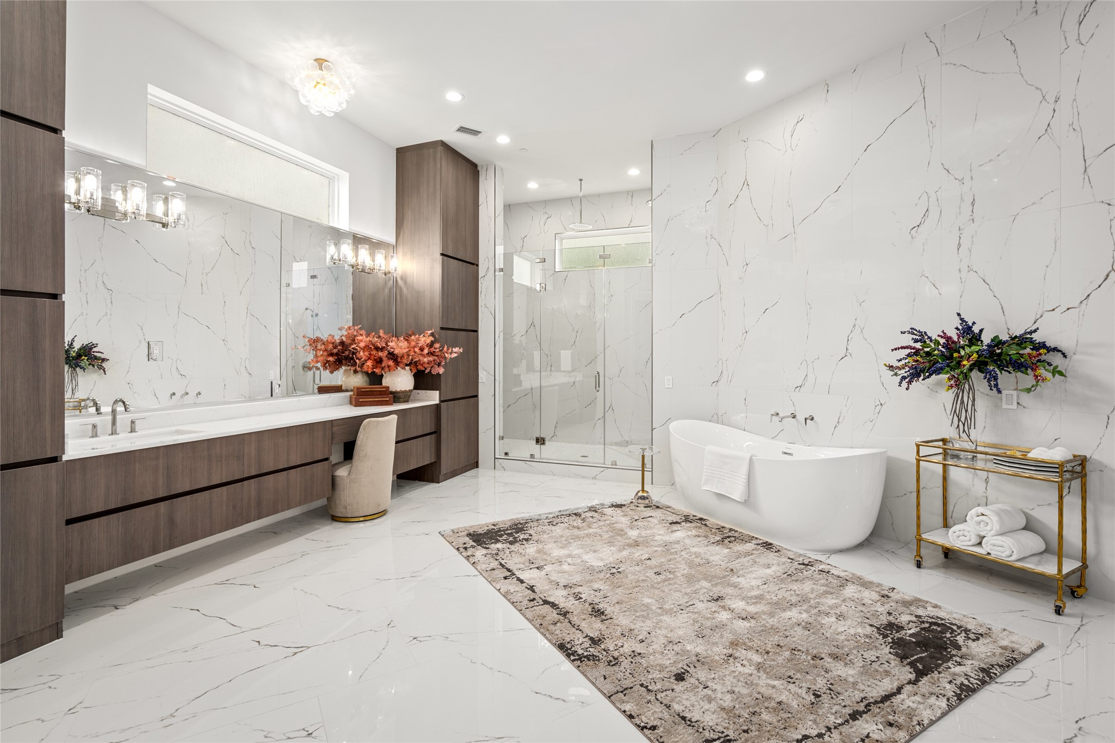 625 Piney Point Road Houston, TX 77024 - Photo 26 of 47 With a footprint rivaling that of the bedroom, the primary bathroom offers an impressive sense of space and serenity. Polished porcelain floors set the stage for two expansive vanities with generous storage, a six-foot freestanding soaking tub, and an oversized walk-in shower featuring multiple body sprays, rain shower & dual showerheads. Polished nickel hardware and a pair of designer glass light fixtures add a refined, spa-like touch.