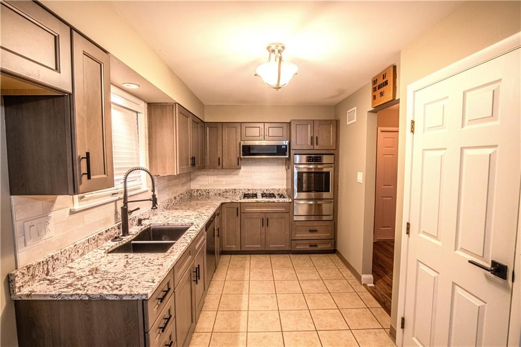 7 Lydia Drive Uniontown, PA 15401 - Photo 12 of 47 a kitchen with stainless steel appliances granite countertop a sink stove and refrigerator
