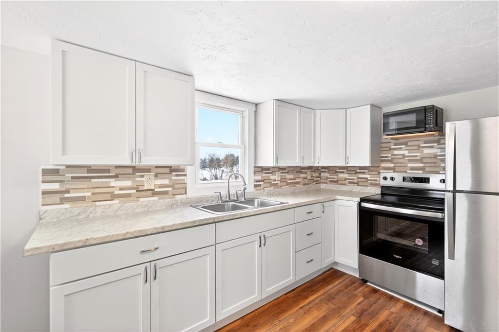 127 Rose Road Mount Pleasant, PA 15666 - Photo 29 of 47 a kitchen with stainless steel appliances granite countertop a sink and cabinets with wooden floor