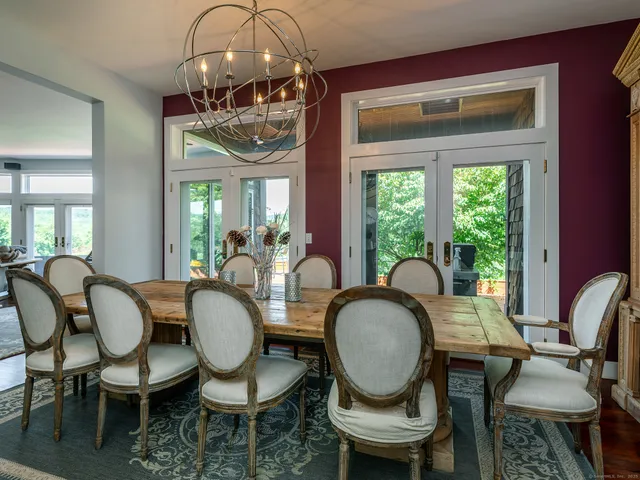 a dining room with furniture a chandelier and wooden floor