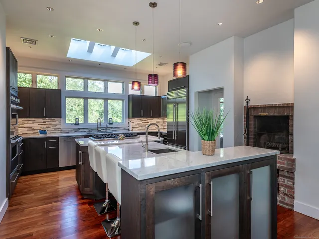 a kitchen with stainless steel appliances granite countertop a sink stove and refrigerator