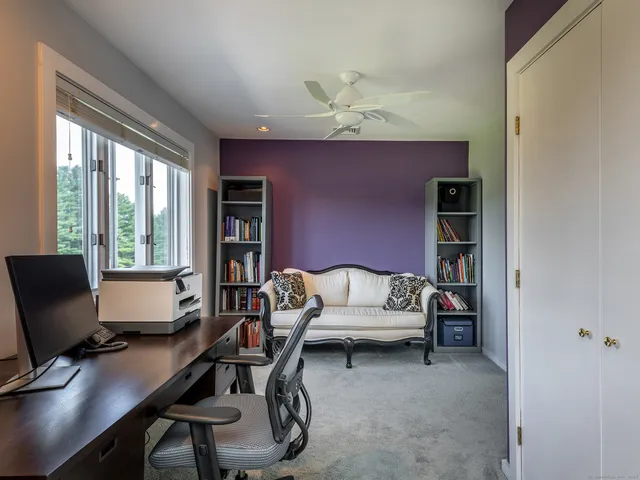 a view of a workspace with furniture and a window