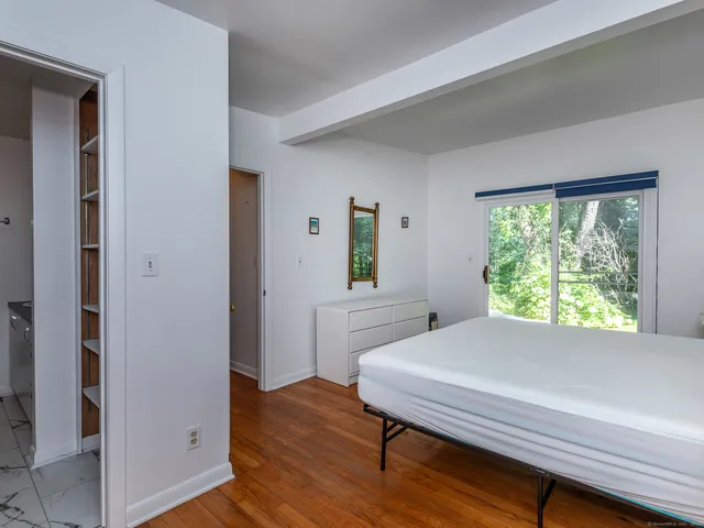 a bedroom with a bed and a dresser next to a window