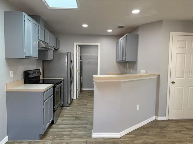 a kitchen with stainless steel appliances a refrigerator sink and cabinets
