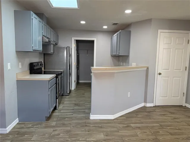 a kitchen with stainless steel appliances granite countertop a refrigerator a stove and a sink