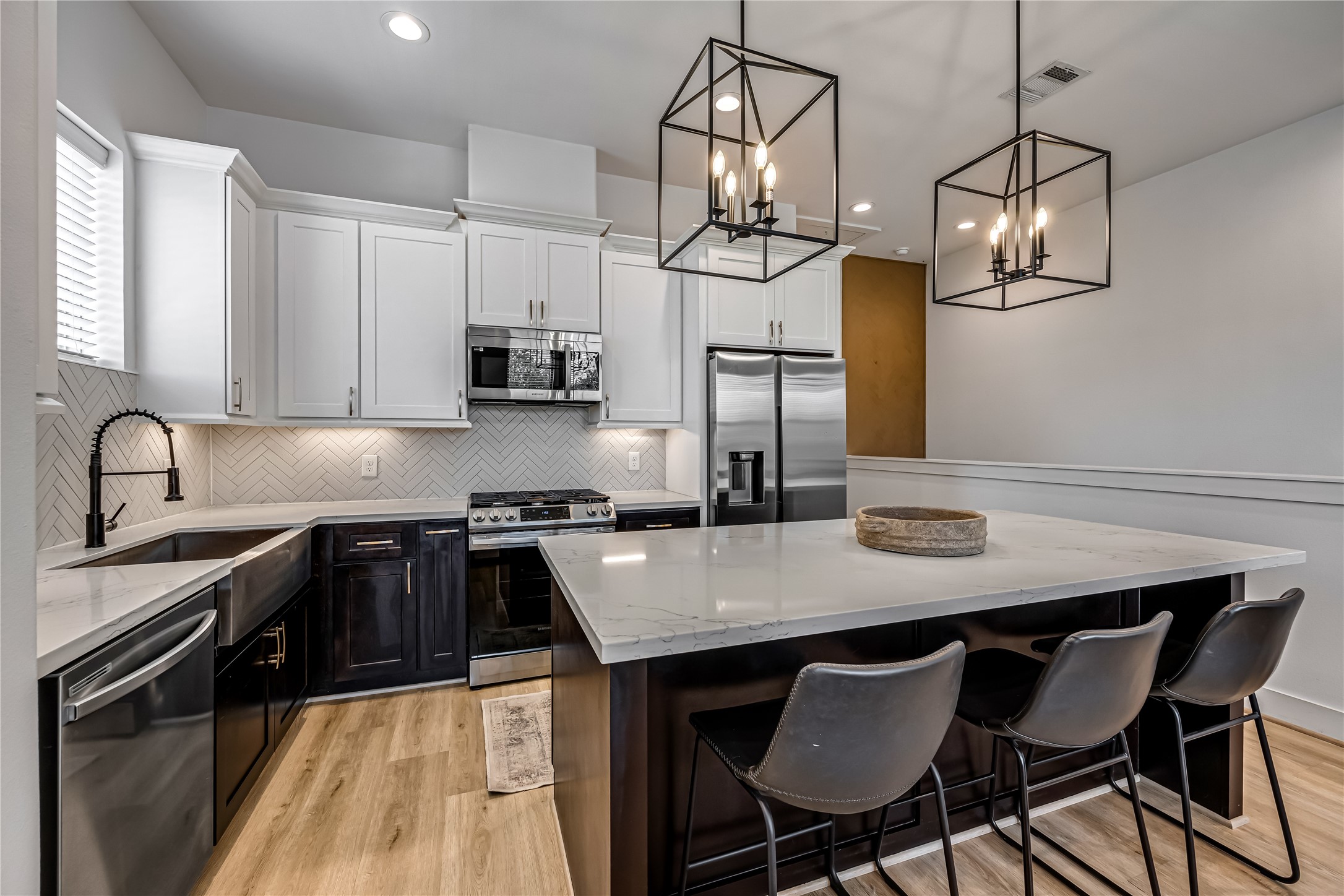 1508 Ryon Street, Unit B Houston, TX 77009 - Photo 13 of 32 Alternate view of the kitchen
space. White cabinetry is
complimented with a white
herringbone patterned
backsplash and durable white
quartz.