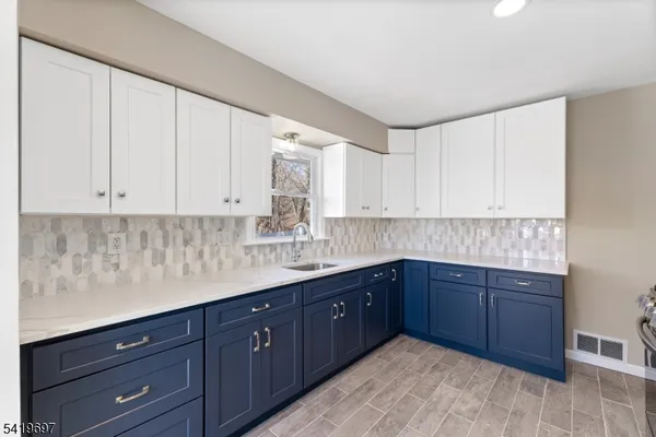 a kitchen with stainless steel appliances granite countertop a sink and cabinets with wooden floor
