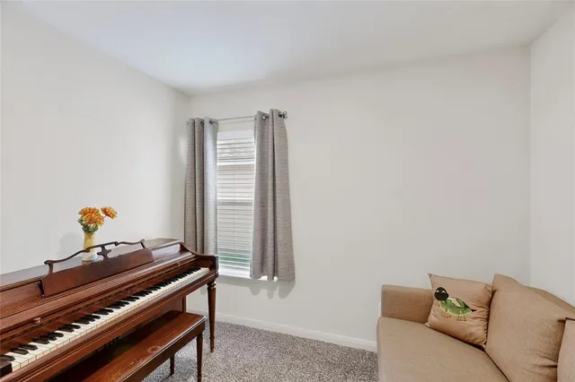 a living room with furniture and a piano