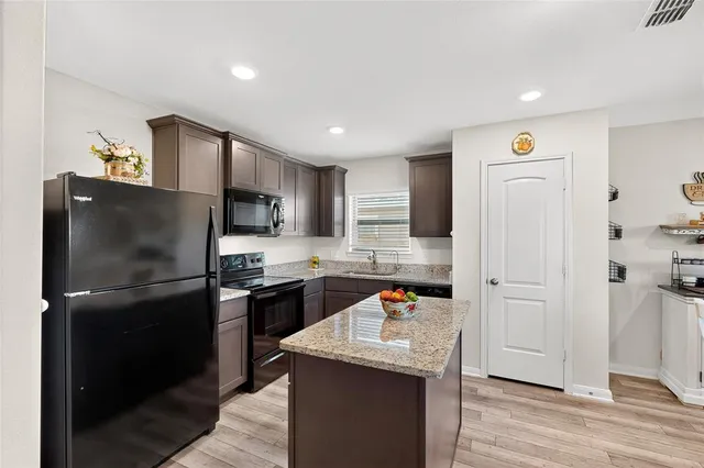 a kitchen with refrigerator and cabinets