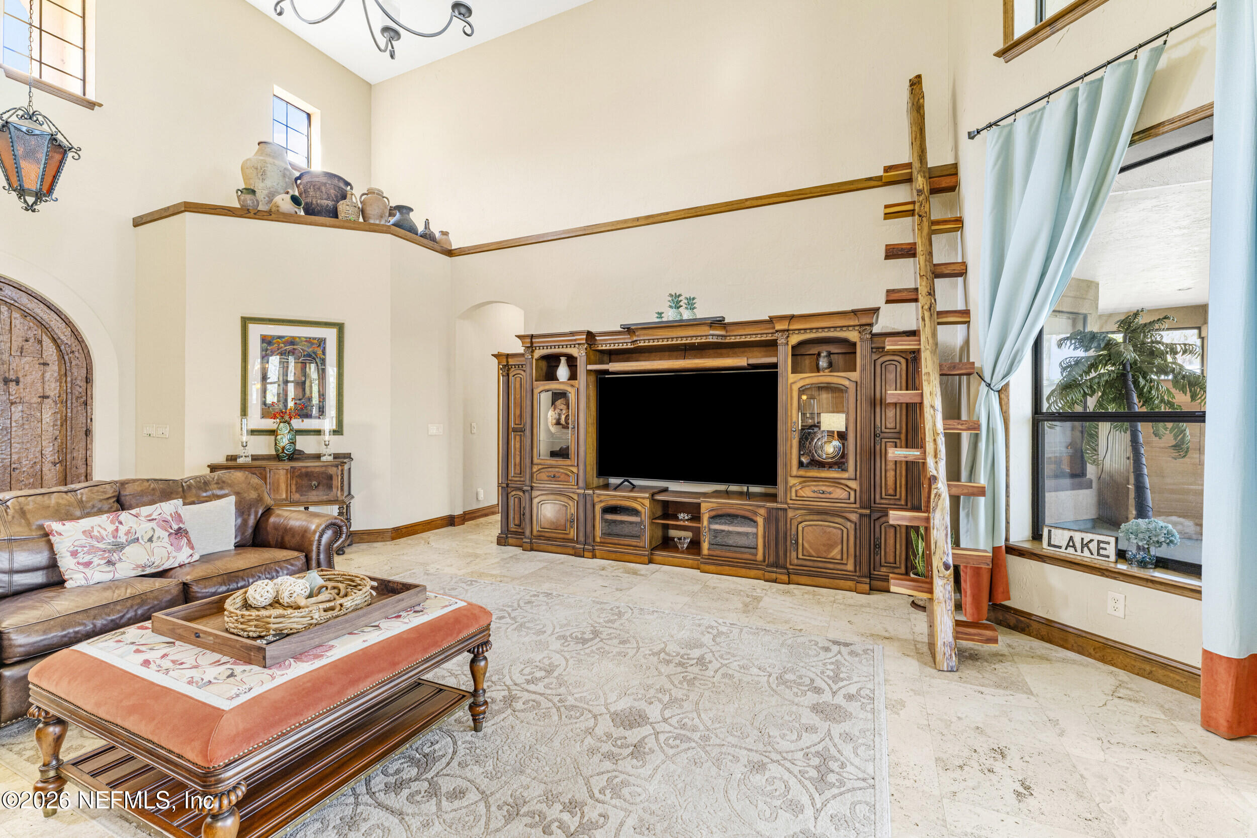 530 Clifton Road Crescent City, FL 32112 - Photo 11 of 68 a living room with furniture a flat screen tv and a floor to ceiling window