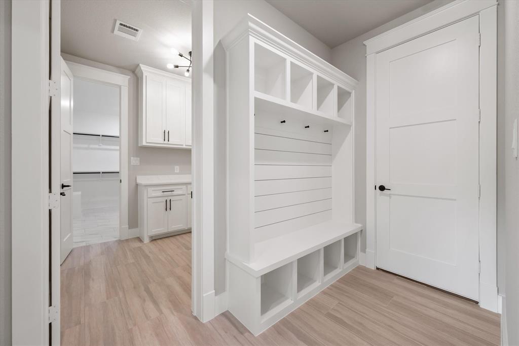 6610 Waggoner Way Midlothian, TX 76065 - Photo 28 of 40 Built-in white mudroom bench with cubby storage, shiplap backing, and coat hooks