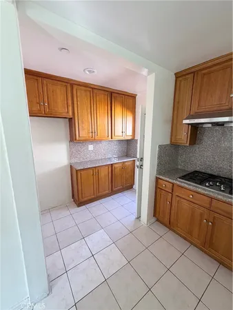 a kitchen with granite countertop a sink window and cabinets