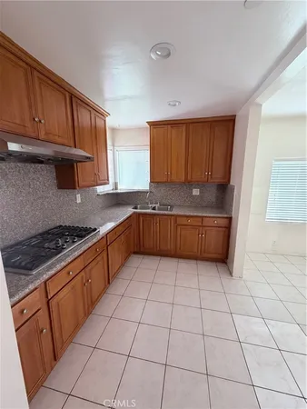 a kitchen with granite countertop a cabinets and a stove top oven