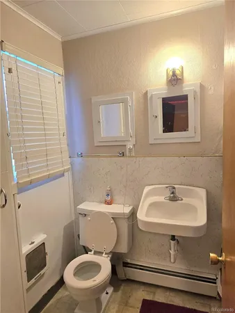 a bathroom with a sink toilet and a mirror