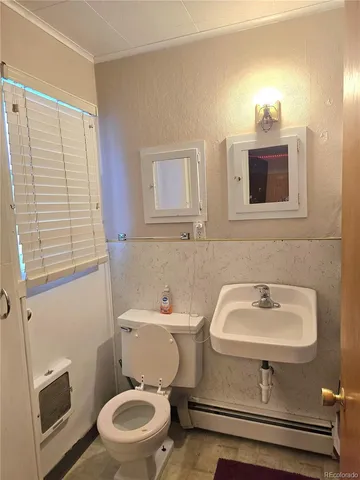 a bathroom with a sink toilet and a mirror