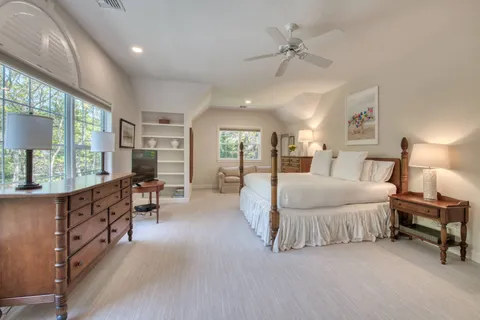 a spacious bedroom with a large bed and a chandelier