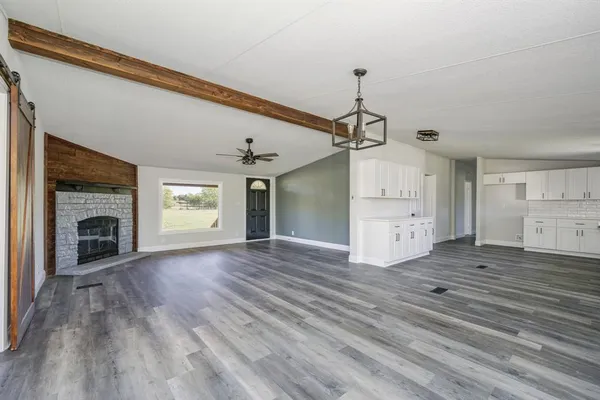 a view of empty room with wooden floor fireplace and windows