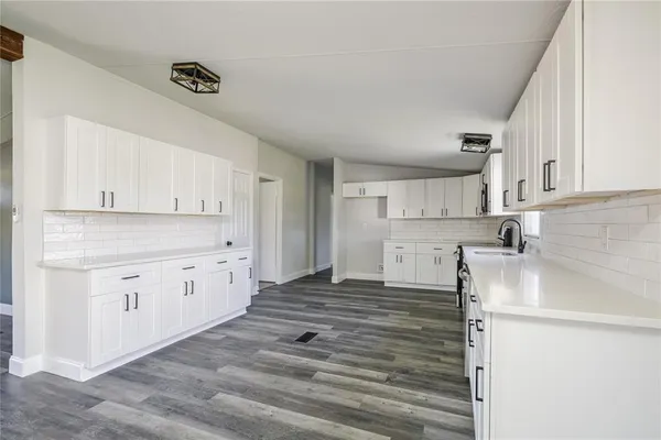 a kitchen with granite countertop white cabinets and white appliances